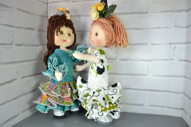 Mu&ntilde;ecas de tela artesanas Maryxeniss vestidas de flamenca: dos mu&ntilde;ecas articuladas simulando un baile de sevillanas con trajes folcl&oacute;ricos y flores en el pelo.