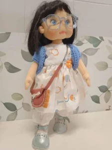 Mu&ntilde;eca de tela hecha a mano pelo negro gafas rebeca ganchillo azul bandolera marr&oacute;n zapatos plateados