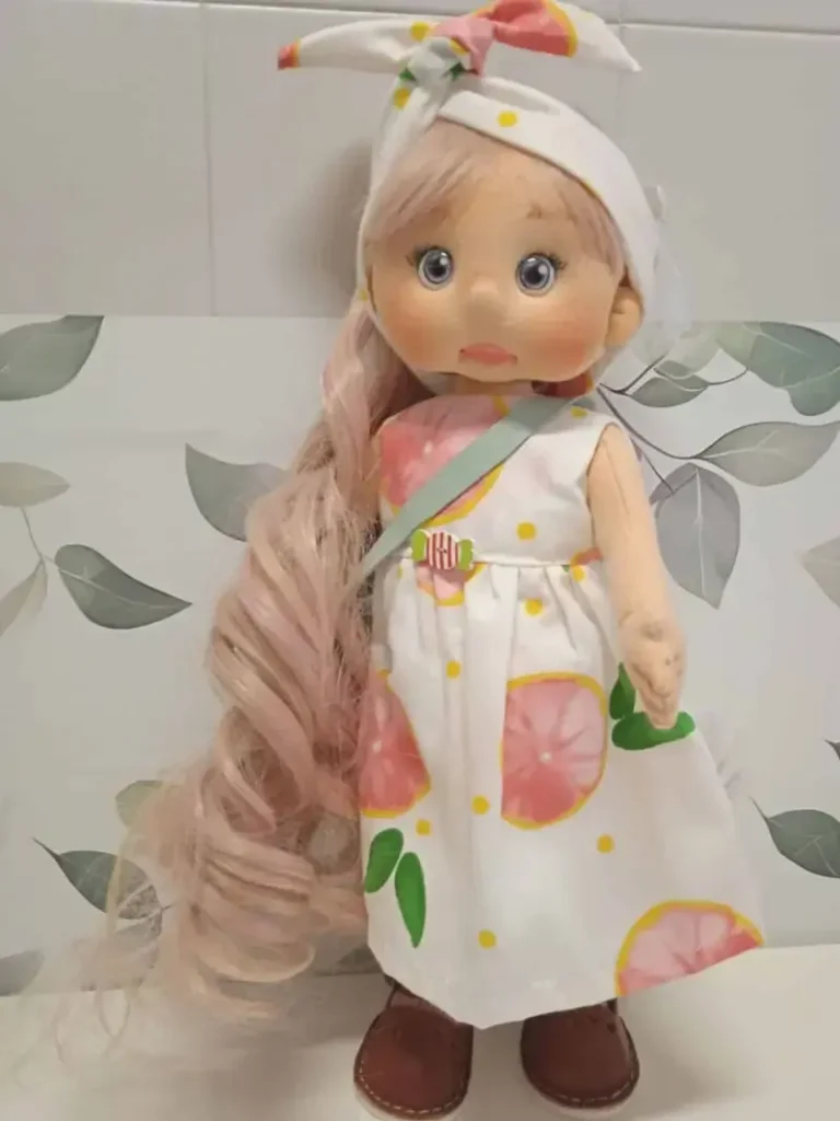 Mu&ntilde;eca de trapo artesanal de estilo Pin-up con pelo largo rubio y un vestido de inspiraci&oacute;n vintage con motivos c&iacute;tricos.