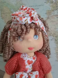 Detalle mu&ntilde;eca de trapo pelo de lana rizado y ojos azules