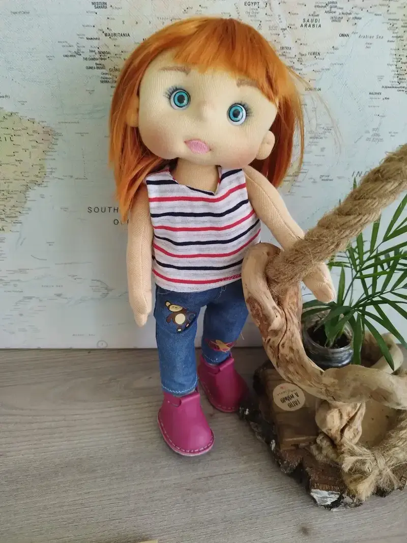 Muñeca artesanal de trapo con estilo moderno, vestida con pantalón vaquero, camiseta y zapatos de piel rosa.