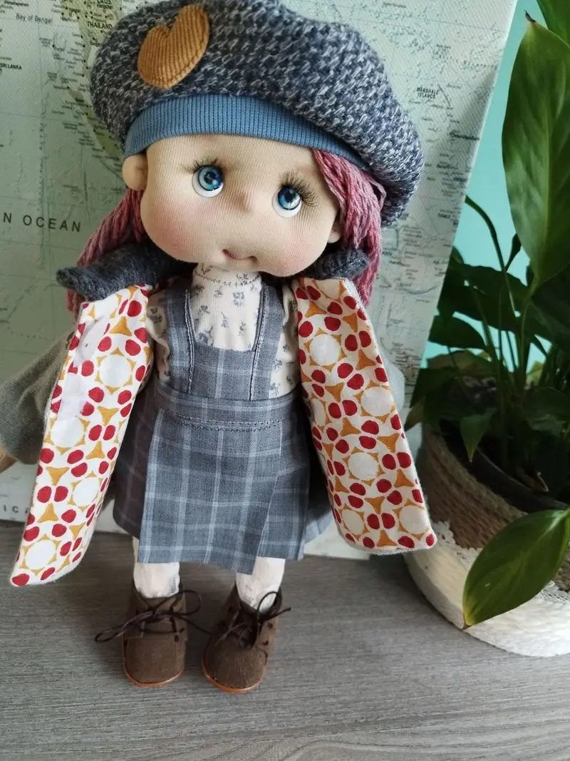 Mu&ntilde;eca de tela artesana Maryxeniss articulada, vestida con abrigo de invierno, boina a juego y botitas.
