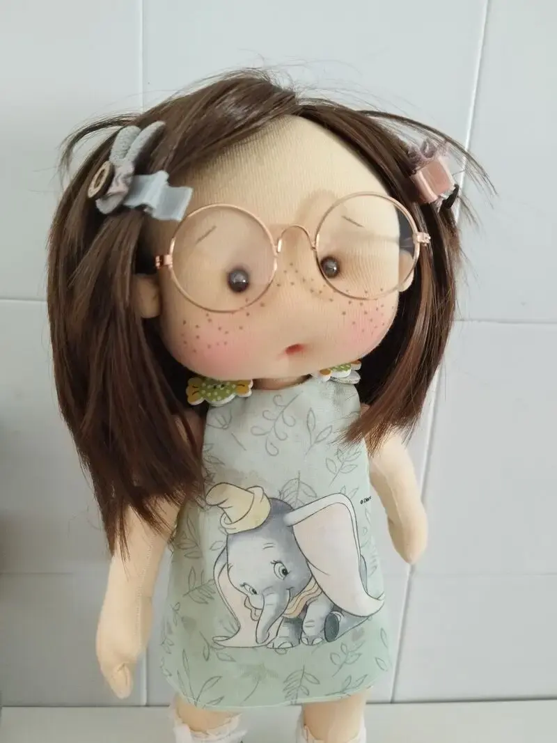 Muñeca de tela artesana Maryxeniss: muñeca con pecas, gafas de alambre, pinzas laterales en el pelo y vestido con estampado de elefantes.