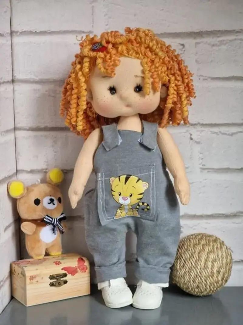 Mu&ntilde;eca de tela artesana Maryxeniss articulada, con pelo de ricitos de lana, peto tejano y un gatito estampado.
