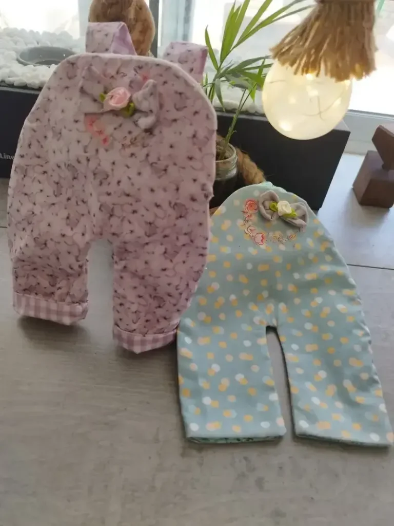 Conjunto de dos petos artesanales de tela confeccionados a mano para vestir mu&ntilde;ecas de trapo.