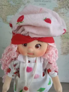 Primer plano del gorro de cocina y el vestido artesanal con estampado de fresas.