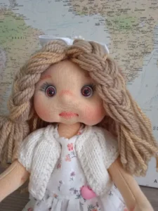 Detalle de los ojos de miel y las trenzas de la mu&ntilde;eca de trapo tipo soft.