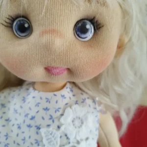 Primer plano mu&ntilde;eca de tela pelo rubio vestido estampado detalle bordado blanco