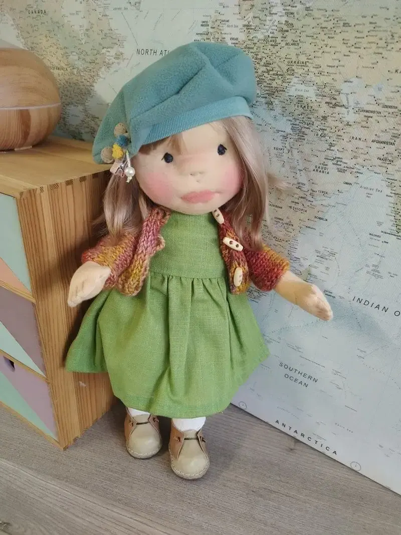 Muñeca Waldorf de tela artesana Maryxeniss: muñeca articulada con boina turquesa, vestido de lino y chaqueta de ganchillo hecha a mano.