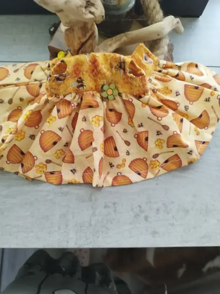 Vestido de algod&oacute;n artesanal para mu&ntilde;ecas de trapo con un alegre estampado de abejas y colmenas.