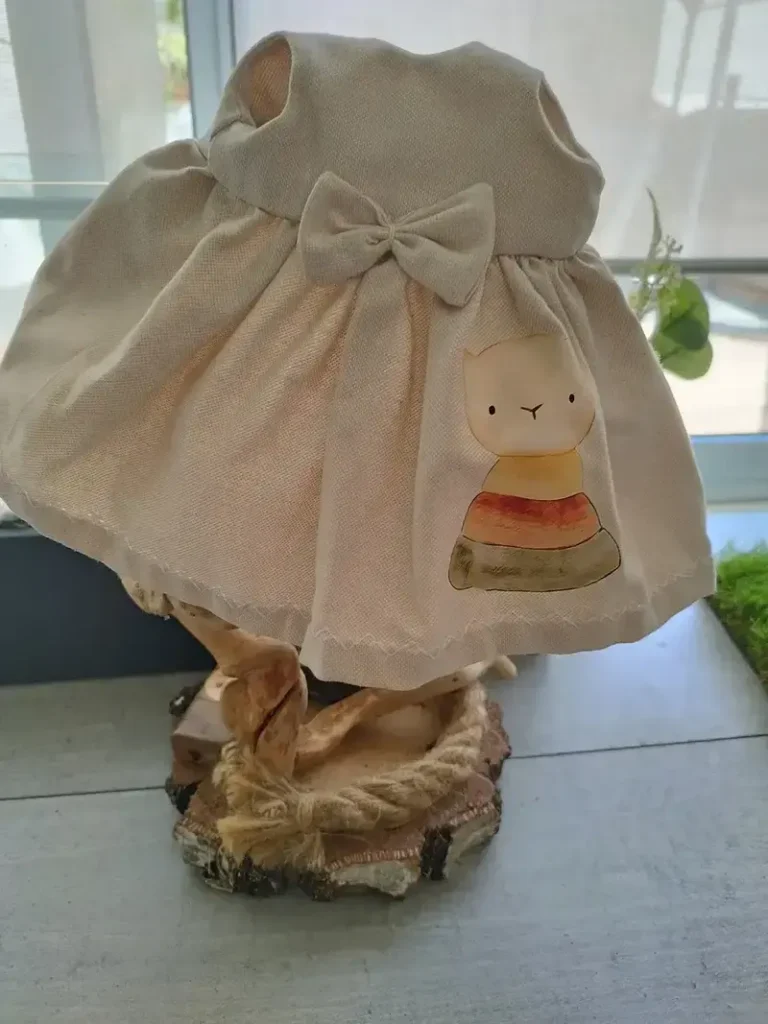 Vestido de lino artesanal en color crudo con lazo en el pecho para mu&ntilde;ecas de tela de 37 cm.